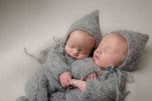 Twins posed holding hands in newborn studio photoshoot